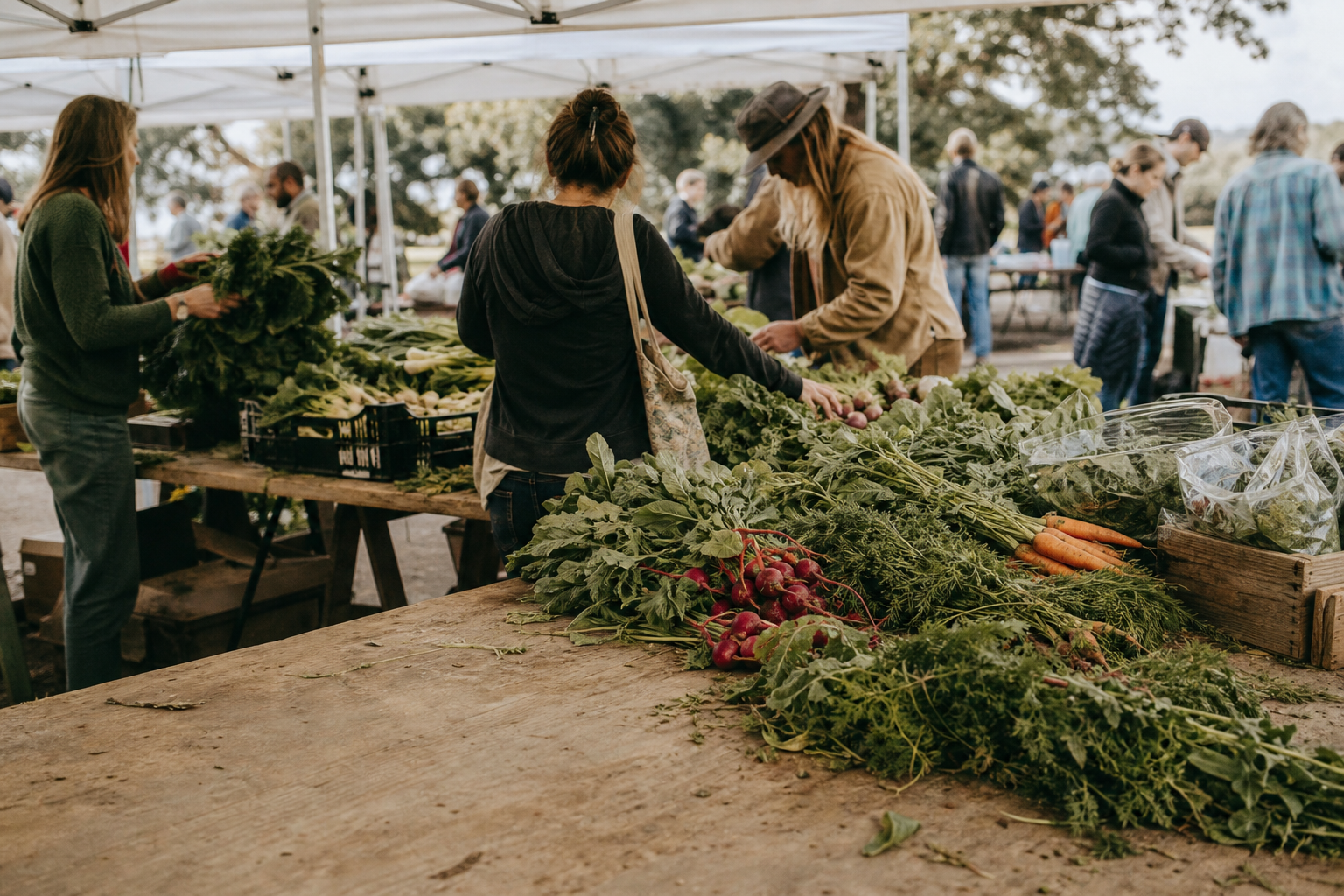 Market shoppers browse fresh produce under outdoor canopies.